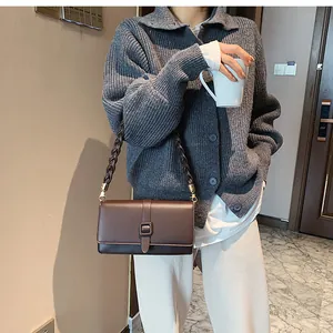 Détail d'un sac bandoulière en cuir marron avec bandoulière tressée et boucle dorée