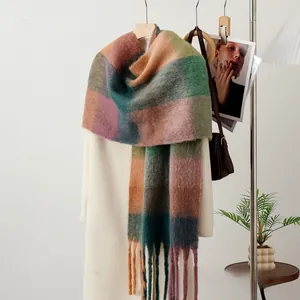 Detail view of colorful plaid mohair scarf with tassels hanging on a white coat