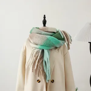 Detail of thick checkered scarf in mint and brown with soft tassel fringes on a coat