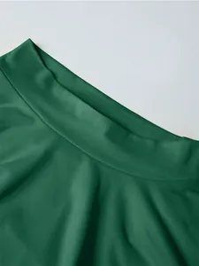 Detail of dark green sleeveless top featuring textured crepe fabric and crew neck