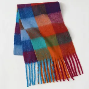 Detail of thick mohair scarf showing vibrant multi-color check patterns and long fringe trim