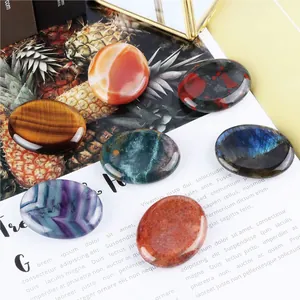 Polished natural crystal palm stones including tiger eye and labradorite on a vintage background