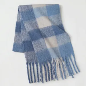 Detailed view of blue and white checkered scarf with soft mohair texture and long tassels
