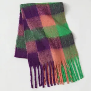 Detail of soft mohair plaid scarf featuring purple, green, and pink colors with long fringes