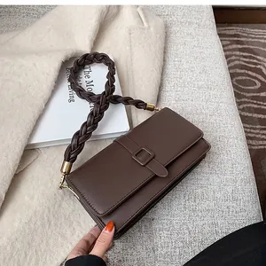 Détail du sac bandoulière en similicuir marron foncé avec bandoulière tressée et boucle