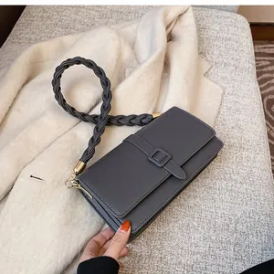 Détail du sac carré en cuir gris foncé avec bandoulière épaisse tressée noire élégante