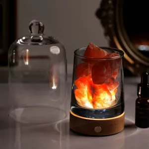 Himalayan salt lamp with orange crystals on wood base and glass cover