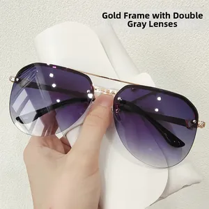 Detail of gold metal frame aviator sunglasses with gradient grey lenses and double bridge