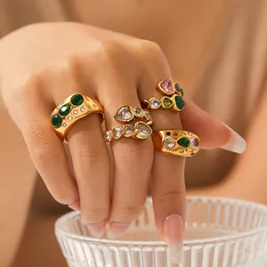 Close-up of luxury gold-plated rings with colorful gemstones worn on hand