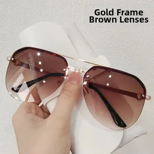 Detail of gold metal frame sunglasses with gradient brown lenses and rivet accents