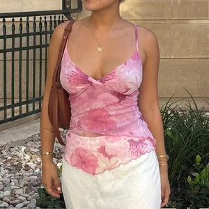 Pink floral mesh camisole with adjustable straps and ruffled hem in Y2K style
