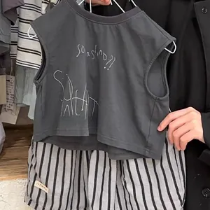 Détail d'un ensemble haut sans manches en coton pour enfant et short rayé