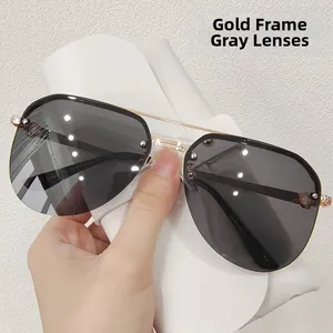 Close-up of gold metal pilot sunglasses with grey lenses and textured hinge details