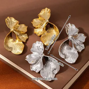 Detail view of large gold and silver flower earrings with pleated texture and measurements
