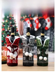 Close-up of three knitted Christmas wine bottle covers with snowflakes and fur trim