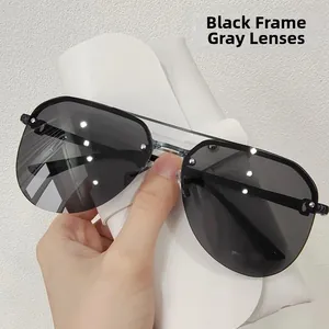 Detail of pilot sunglasses with black frame, grey lenses and metal rivet accents