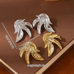Macro view of gold and silver flame-shaped earrings with mirror polished finish