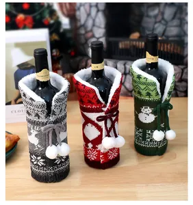 Close-up of thick knitted wine bottle covers with plush lining and white pom-poms