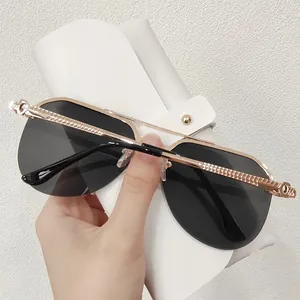 Detail of rose gold metal sunglasses with spiral textured temples and leather case