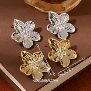 Detailed view of large metallic flower earrings in gold and silver with size dimensions