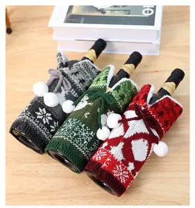 Close-up of knit Christmas wine bottle covers with snowflakes and white pom-poms
