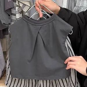 Vue détaillée du haut sans manches en coton gris foncé pour enfant avec col plissé