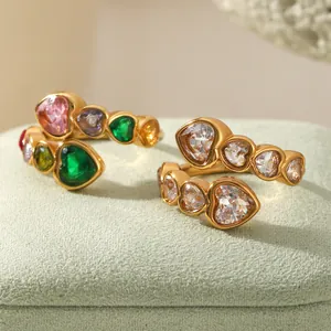 Macro detail of gold open rings with colorful heart-shaped cubic zirconia and clear stones