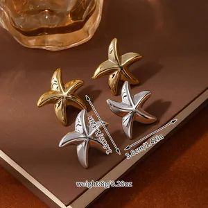 Detailed size and weight view of gold and silver starfish earrings on a book