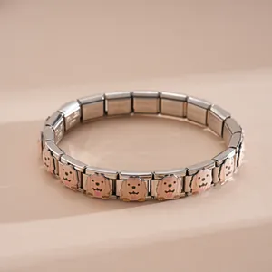 Macro view of modular stainless steel bracelet with golden retriever enamel patterns