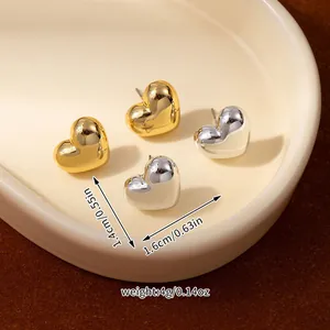 Macro shot of 3D heart stud earrings with dimensions in gold and silver finish