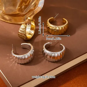 Detail view of 3cm gold and silver chunky C-shaped hoop earrings with vertical ribbed texture