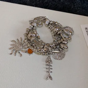 Silver multi-layer beaded bracelet with sun, starfish, and seashell charms for summer
