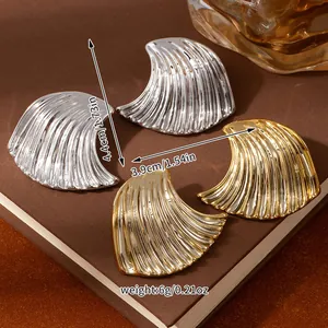 Macro view of gold and silver wave-textured petal earrings with specific size measurements