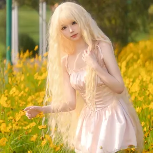 Detailed view of long wavy pale gold synthetic wig against a sunny floral background