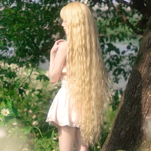 Detail of extra long light blonde wavy wig with natural curls in outdoor sunlight