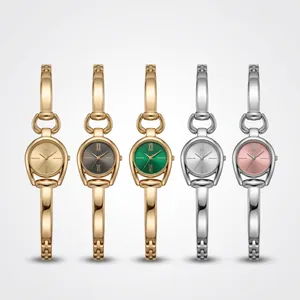 Macro view of horsebit-style bangle watches in gold and silver with Roman numeral dials