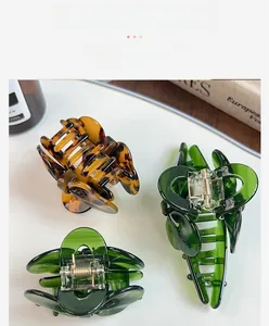 Detail view of durable acetate hair claws with premium metal springs in leopard and green
