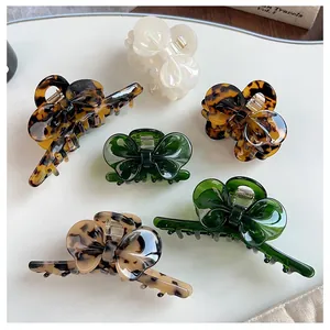Detailed top view of assorted acetate bow hair claws in tortoiseshell and pearlescent colors