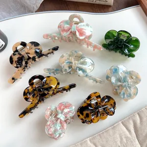 Set of eight assorted acetate bow hair clips with marble patterns and tortoiseshell finish