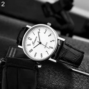 Detailed close-up of a silver quartz watch with white dial and black leather strap