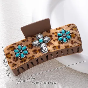 Detail of leopard print hair claw clip with turquoise flowers and silver cross ornament