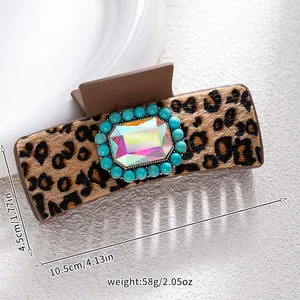 Detail view of large leopard print hair claw clip with turquoise beads and faux gemstone