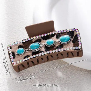 Detail view of leopard print hair claw clip with turquoise stones and rhinestones