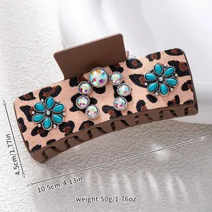 Detailed view of leopard print hair claw clip with turquoise flowers and rhinestones