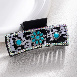 Detail of cow print hair claw with turquoise stone and sparkling rhinestones