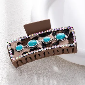 Detail of leopard print hair claw clip featuring turquoise stones and crystal borders