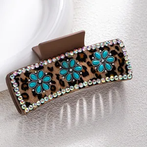 Detail of leopard print hair claw clip with turquoise-style floral inlay and rhinestones