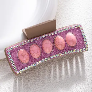 Detail of pink glitter hair claw clip with faux stone inlay and colorful rhinestones