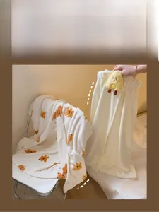 Detail of coral fleece bath towel with bear pattern, velcro closure, and plush duck decor