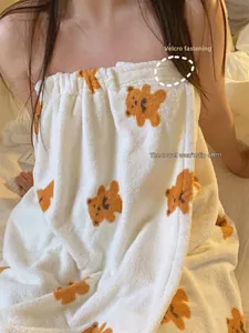 Detail of soft coral fleece bath wrap featuring orange bear print and velcro closure